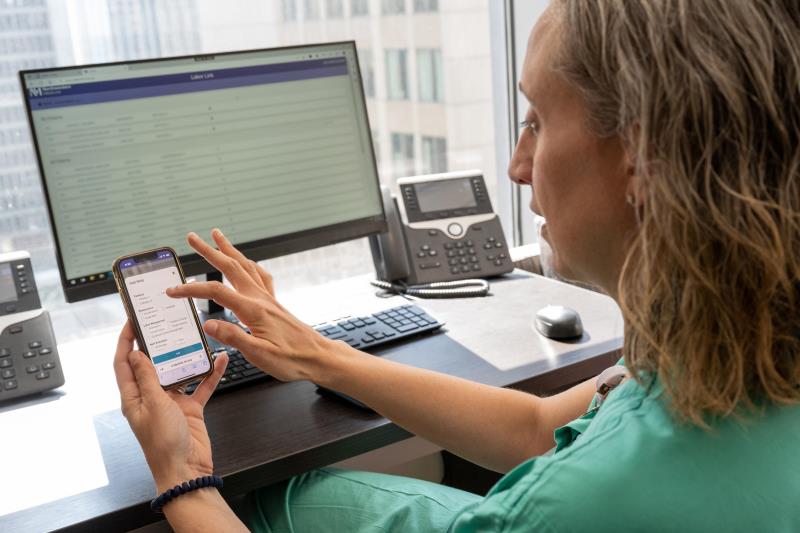 Clinician looking at phone and desktop
